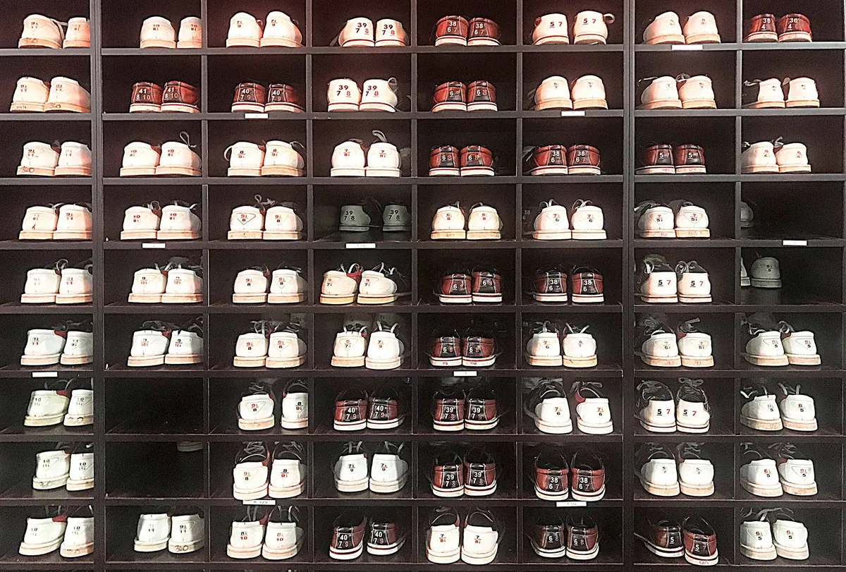 Casiers de chaussures de bowling de location rangées par pointure à l'accueil d'une salle