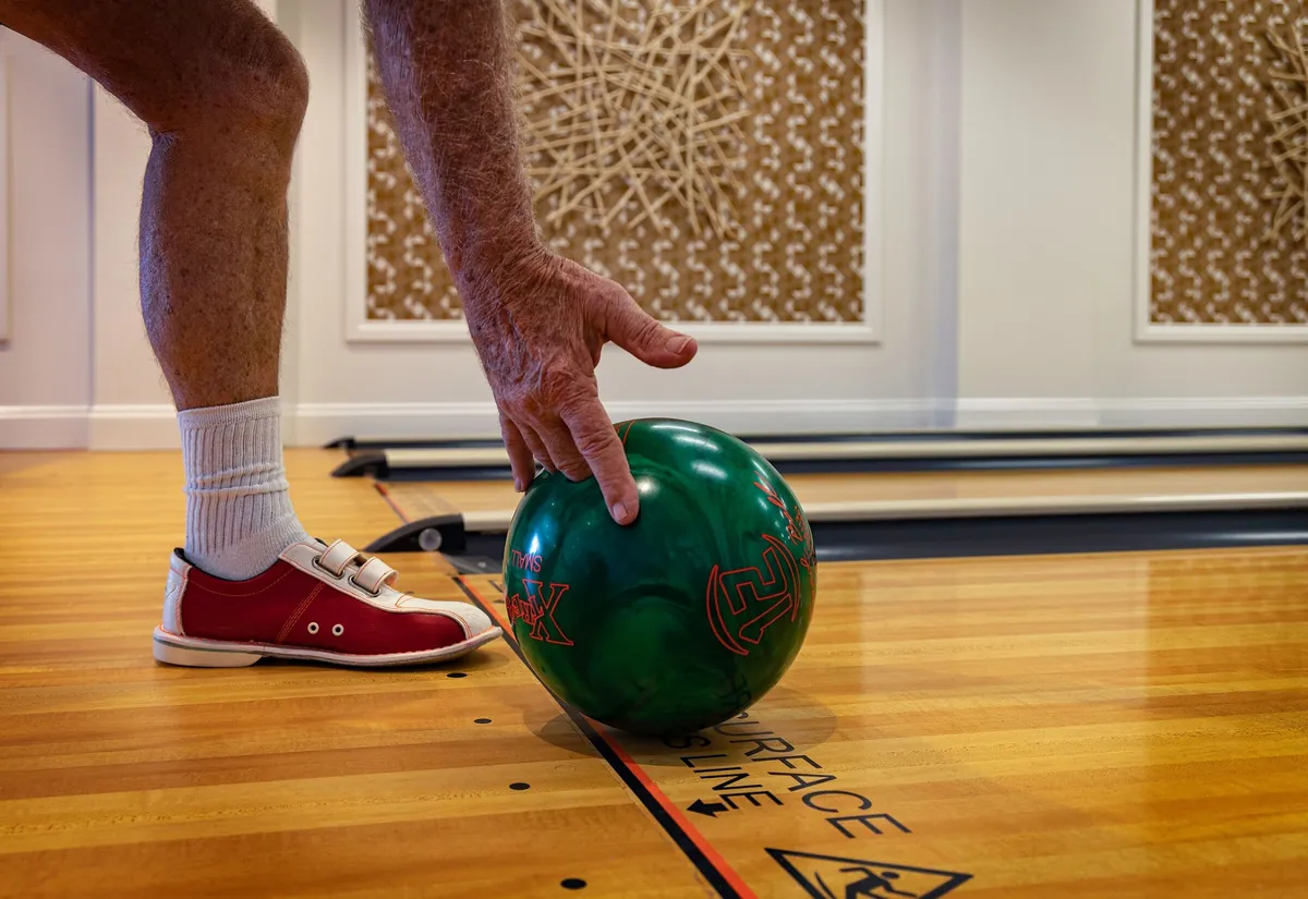 Pied d'un joueur juste derrière la ligne de faute au moment de poser la boule sur la piste